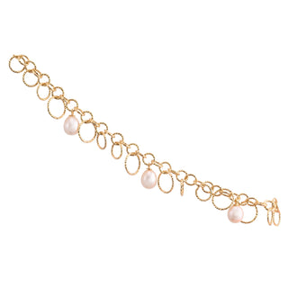 Sterling Silver bracelet with yellow gold plating and a shiny, diamond-cut finish, featuring multiple round rings of different sizes and teardrop-shaped freshwater pearls by Gexist®