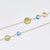 Sterling silver and yellow gold plating necklace, with a modern combination of brushed discs, pearls and faceted blue topaz by Gexist®