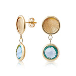 Sterling silver and yellow gold plating stud earrings, composed of 2 different finishing elements, one flat brushed disc followed by a faceted blue topaz by Gexist®