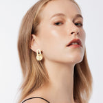 Sterling silver and yellow gold plating stud earrings, consisting of an oval-shaped element connected to a disc, both with a brushed finish by Gexist®