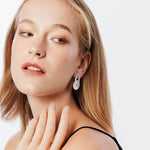 Stud earrings in Sterling Silver consisting of an oval-shaped element connected to a disc, both with a brushed finish by Gexist®
